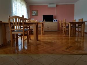 a dining room with a table and chairs and a television at House Kajfes in Plitvička Jezera