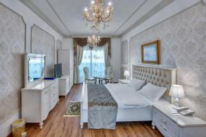 a bedroom with a large white bed and a chandelier at Royal Hotel in Sharjah