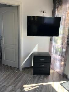 a flat screen tv hanging on a wall above a dresser at Ferienhaus Eichhorn in Breege