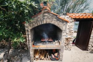 a stone oven with a fire inside of it at Apartments KraljicaMira in Splitska