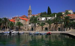 a group of boats in the water in front of a building at Apartments KraljicaMira in Splitska