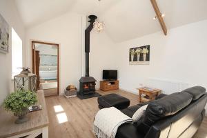 a living room with a couch and a wood stove at The Old Stables in Taunton