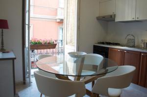 une salle à manger avec une table en verre et des chaises blanches dans l'établissement New Romantic Suite, à Cagliari