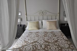 um quarto com uma cama grande, uma grande cabeceira e almofadas em New Romantic Suite em Cagliari