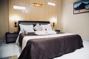 a bedroom with a large bed with two stuffed animals on it at Hôtel IMAN in Nouakchott