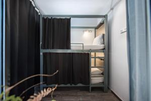 um pequeno quarto com um beliche e um espelho em Bedbox Hostel em Atenas