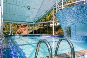 a large swimming pool with a water fountain at Hotel Fazenda Golden Park Campos do Jordão in Campos do Jordão