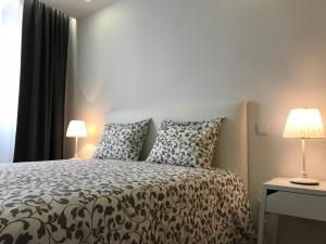 a bedroom with a black and white bed with two lamps at Povoa do Mar in Póvoa de Varzim +91 photos