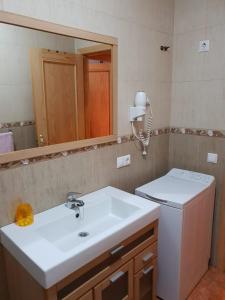 y baño con lavabo blanco y espejo. en Alojamiento Alarcon, en Arroyo Frío