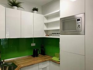 a kitchen with white cabinets and a microwave at Apartmán FRANZ in Tatranská Lomnica