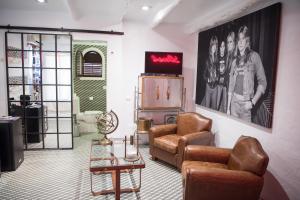 a living room with two chairs and a tv at Pikes Ibiza in San Antonio