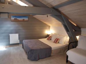 a bedroom with a bed and a chair in a attic at L'Estanquet Bed and Breakfast pdj offert in Gastes