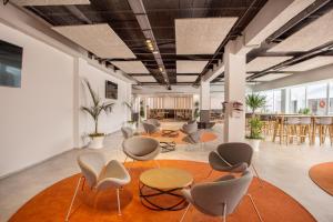 Großes Zimmer mit Stühlen und Tischen sowie einer Küche in der Unterkunft Planet Hotels ONE - Adults Only 16 years in El Arenal