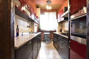 a kitchen with dark cabinets and a large window at Tbilisi Art Apartment in Tbilisi City
