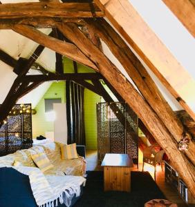 una sala de estar con un ático con vigas de madera en Domaine de Vandenesse & Spa, en Vandenesse-en-Auxois