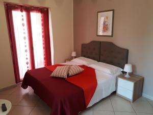 1 dormitorio con 1 cama con manta roja en Casa Vacanza "La Chiazza di Grutti", en Grotte