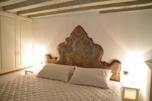 sypialnia z dużym łóżkiem z drewnianym zagłówkiem w obiekcie Ca' Mariele w Wenecji