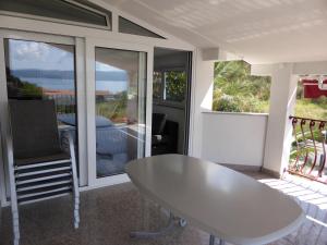 a white table and chair in a room with sliding glass doors at Ferienwohnung Dalmatien in Dugi Rat