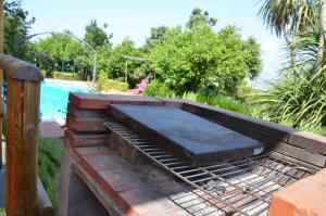 un patio con barbacoa junto a la piscina en Desiderio D'Ammore, en Corbara