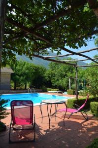 een tafel en twee stoelen voor een zwembad bij Desiderio D'Ammore in Corbara