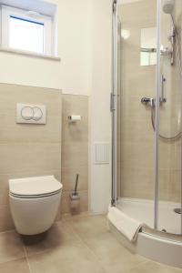 uma casa de banho com um WC e uma cabina de duche em vidro. em Hotel Major Budget em Cracóvia
