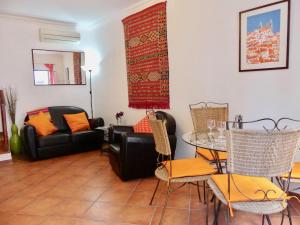 een woonkamer met een bank en een tafel en stoelen bij Kasa Sunshine in Olhão