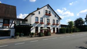 a white building on the side of a street at Gasthof zur Post in Cobbenrode