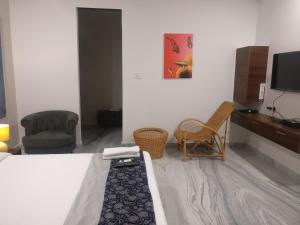 a room with a bed and two chairs and a tv at Misty Lake Guest House in Hyderabad +29 photos