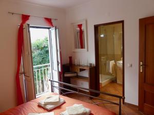 Habitación con cama y baño con balcón. en Kasa Sunshine, en Olhão