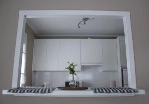 a kitchen with white cabinets and a vase of flowers on a counter at La Posada de Granda in Cuenco