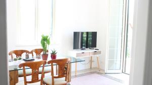 a dining room with a table with chairs and a television at Beach House Mondello in Mondello