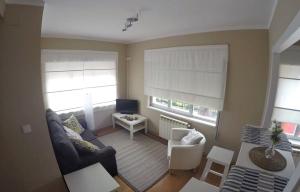 a living room with a couch and a table and two windows at La Posada de Granda in Cuenco +3 photos