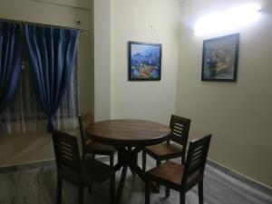 uma mesa de madeira e cadeiras num quarto em Misty Lake Guest House em Hyderabad