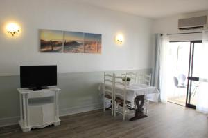 ラゴスにあるBeach and Pool Studio Apartmentのリビングルーム(テレビ、テーブル、テレビ付)