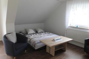 a bedroom with a bed and a table and a chair at FEWO Familie Werner in Erfurt