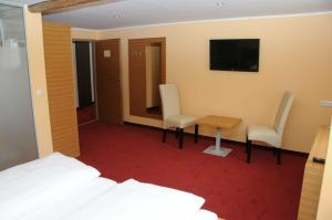 a hotel room with a bed and a table and chairs at Hotel Stiegenwirt in Schärding