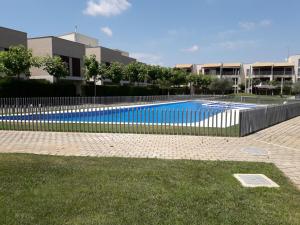 a swimming pool with a fence in front of a building at Sant Jordi club de golf apart 4 x 2 in Sant Jordi