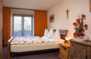 a bedroom with a bed with a cross on the wall at Gasthof Jägerklause in Stummerberg