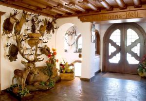 une chambre avec des bois de cerfs sur le mur et une porte dans l'établissement Gasthof Jägerklause, à Stummerberg