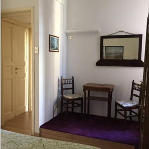 a room with two chairs and a table and a mirror at b&b Gio Colosseo - Celio in Rome