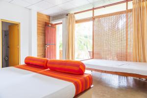a bedroom with two beds and a large window at Liyana Holiday resort in Anuradhapura