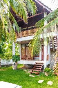 a house with a porch with a deck and benches at Liyana Holiday resort in Anuradhapura