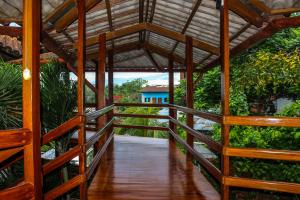 a wooden walkway leading to a house with a roof at Hotel Rio Huallaga in Yurimaguas