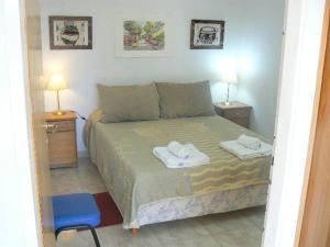 1 dormitorio con 1 cama con 2 toallas en Departamentos Santa Monica en Puerto Madryn