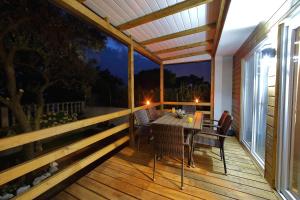 a wooden deck with a table and chairs on it at Mobile homes Olive and Sea in Bibinje