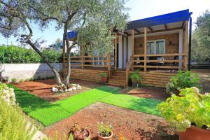 a small house with a yard with grass at Mobile homes Olive and Sea in Bibinje