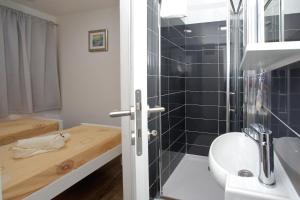 a small bathroom with a bed and a shower at Mobile homes Olive and Sea in Bibinje +37 photos