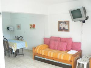 ein Wohnzimmer mit Sofa und Tisch in der Unterkunft Departamentos Santa Monica in Puerto Madryn