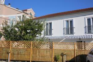 a wooden fence in front of a white house at Boho House in Pakoštane