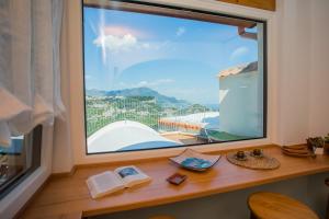 une fenêtre dans une pièce avec vue sur une piscine dans l'établissement DAME casa vacanza, à Amalfi 25 autres photos